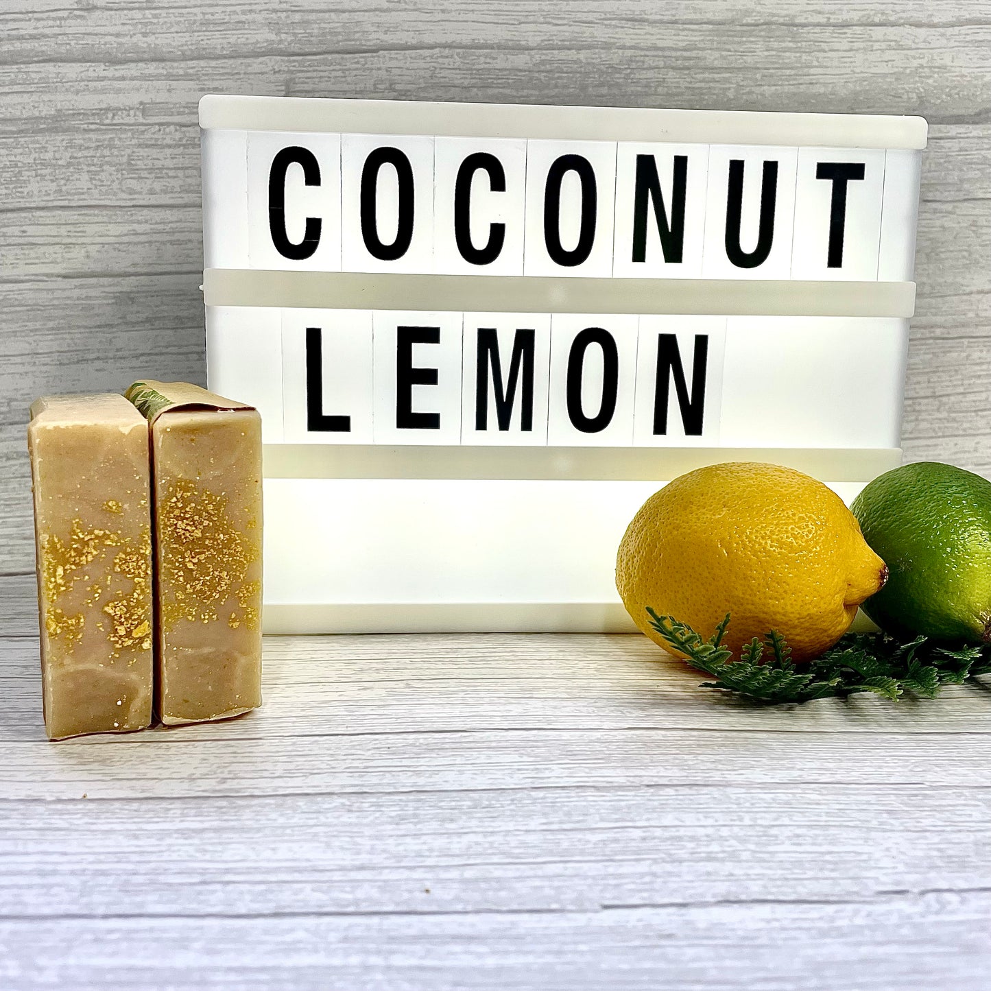 Coconut Lemon billboard with 2 handcrafted soaps positioned to show the tops sprinkled with real lemon peel