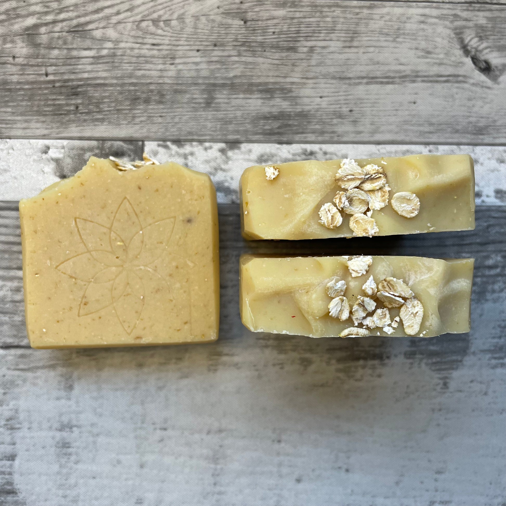2 honey and oat handcrafted soaps to show the creamy texture of the top and the front side of the soap with Basic Senses logo stamped